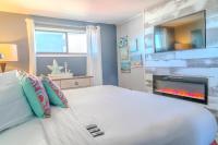 Schlafzimmer mit einem großen Bett, einem Kamin und einem TV in der Unterkunft Ocean View Double Suite! Sleeps 4 Meridian Plaza 705 in Myrtle Beach