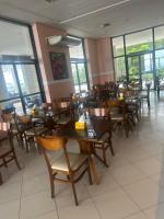 マナウスにあるFlat vista Rioの木製のテーブルと椅子と窓のあるレストラン