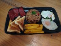 una bandeja negra de comida para el desayuno con huevos, salchichas y pan en Blue Iguana, en Sámara