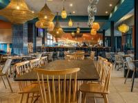 een restaurant met een tafel en stoelen en een bar bij 2Bed Serene Lagoon Escape in Pretoria