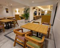 Un comedor con mesas y sillas de madera. en HOTEL SR, en Palani
