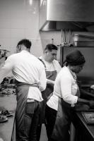 Tres personas de pie en una cocina preparando comida. en Pillows City Hotel Brussels Centre, en Bruselas