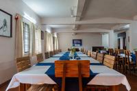 Un comedor largo con una mesa azul y blanca. en Gama Heritage Residency, en Kochi