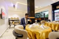 a man sitting at a table in a restaurant at Roston Hotels in Port Harcourt