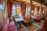 een restaurant met rode cabines en tafels en ramen bij Gasthaus Gästekiste in Augsburg