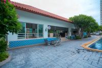 a house with a table and chairs next to a pool at Jomtien Beachside Studio at View Talay5 in Pattaya South