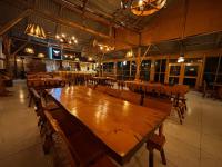 an empty restaurant with a large wooden table and chairs at Hotel El Rancho in Concepción