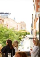 Un grupo de personas sentadas en una mesa con copas de vino. en The Richmond Hotel - Adelaide, en Adelaida