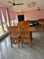 een eetkamer met een houten tafel en stoelen bij Prantik Hotel And Resorts in Tajpur