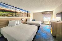 Una habitación de hotel con dos camas y un cuadro en la pared. en Days Inn &amp; Suites by Wyndham New Iberia, en New Iberia