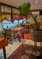 un ristorante con tavoli e sedie e una pianta in vaso di Le vent des globes a Les Sables-dʼOlonne