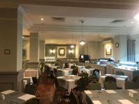 een eetkamer met witte tafels en stoelen bij The Windsor Hotel in Sliema