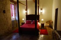 a bedroom with a four poster bed with red sheets at Un Coin de Paradis in Cologne