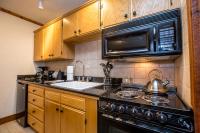 a kitchen with a stove and a sink and a microwave at Kandahar Lodge at Whitefish Mountain Resort in Whitefish