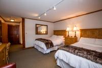 a hotel room with two beds and a mirror at Kandahar Lodge at Whitefish Mountain Resort in Whitefish