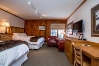 a hotel room with two beds and a desk at Kandahar Lodge at Whitefish Mountain Resort in Whitefish