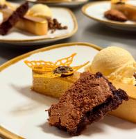 a plate with a piece of cake and ice cream at Eilandhotel Texel - Nieuw geopend hotel in De Cocksdorp