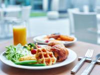 two plates of breakfast food and a glass of orange juice at Miyako Hotel Kyoto Hachijo in Kyoto