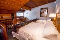 a bedroom with three beds in a room with wooden ceilings at Kandahar Lodge at Whitefish Mountain Resort in Whitefish