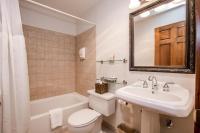 a bathroom with a sink and a toilet and a bath tub at Kandahar Lodge at Whitefish Mountain Resort in Whitefish