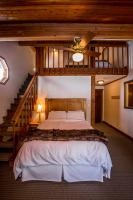 a bedroom with a large bed and a staircase at Kandahar Lodge at Whitefish Mountain Resort in Whitefish