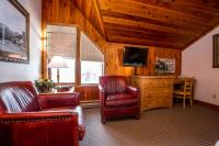 a living room with two chairs and a television at Kandahar Lodge at Whitefish Mountain Resort in Whitefish