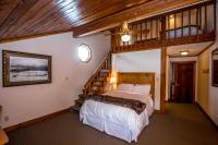 a bedroom with a large bed and a staircase at Kandahar Lodge at Whitefish Mountain Resort in Whitefish