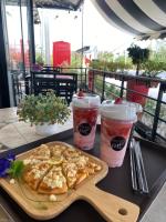 a table with a plate of food and two cups of drinks at Sweet me homestay in Changwat Maha Sarakham