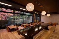 くらま温泉 في كيوتو: غرفة كبيرة بها طاولات وكراسي ونوافذ كبيرة