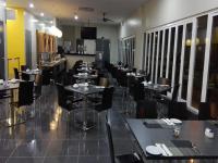 Un comedor con mesas y sillas en un restaurante. en Nadias Hotel Cenang Langkawi, en Pantai Cenang