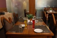 una mesa de madera con platos y vasos. en NPG Hotel, Near Kempegowda International Airport, en Dod Jāla