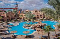 an image of a resort pool with palm trees and umbrellas at Charmillion Gardens Aquapark in Sharm El Sheikh