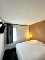 Un dormitorio con una cama blanca y una ventana. en Fasthotel Laval, en Laval