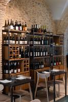 een kamer met 2 tafels en flessen wijn bij La Corte degli Archi in Benevento