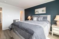 ein Schlafzimmer mit einem großen Bett mit einer blauen Wand in der Unterkunft Windy Waves Top Location w Pool in Myrtle Beach