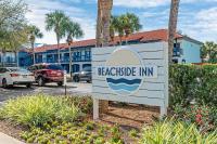 ein Schild für ein Gasthaus am Strand auf einem Parkplatz in der Unterkunft Beachside Inn in Destin