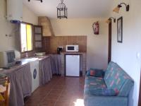 a living room with a couch and a kitchen at Apartamentos Daper in Facinas