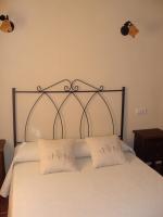 a bed with a metal headboard and two pillows at Apartamentos Daper in Facinas