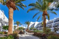 a row of palm trees in front of a building at Sol Fuerteventura Jandia - All Suites in Morro del Jable