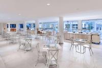 a cafeteria with tables and chairs in a building at Sol Fuerteventura Jandia - All Suites in Morro del Jable