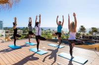 a group of people doing yoga on the roof of a building at Sol Fuerteventura Jandia - All Suites in Morro del Jable