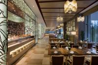 Un restaurante con mesas y sillas de madera y un mostrador. en Pullman Wenzhou, en Wenzhou