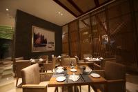 Un restaurante con mesas y sillas y un gran ventanal. en Pullman Wenzhou, en Wenzhou