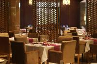 un comedor con mesas, sillas y mesa de comedor en Pullman Wenzhou, en Wenzhou