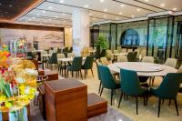 un restaurant avec des tables et des chaises dans un bâtiment dans l'établissement Shougang Qian'an Conference Center, à Qian'an