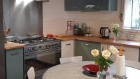 a kitchen with a stove and a table with flowers at Le Mas Nomade in Callian