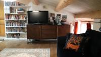 a living room with a couch and a tv on a dresser at Le Mas Nomade in Callian