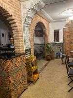 Habitación con pared de ladrillo, mesa y sillas. en Dar Rif Kebdani, en Tánger