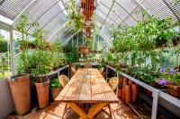 Un invernadero con mesas y plantas en macetas. en Domaine Ablon, en Ablon