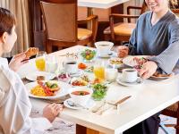 two women sitting at a table eating breakfast at Hotel Grand Tiara Minaminagoya in Anjo